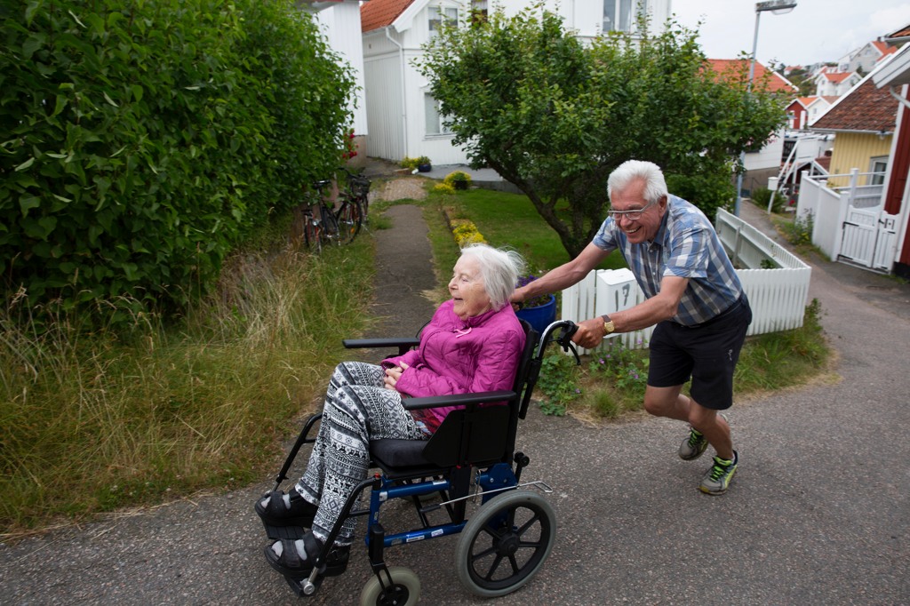 Ett par på väg uppför en backe i rullstol.