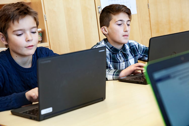 bild på två unga pojkar med varsin dator i skolmiljö, foto scandinav.se