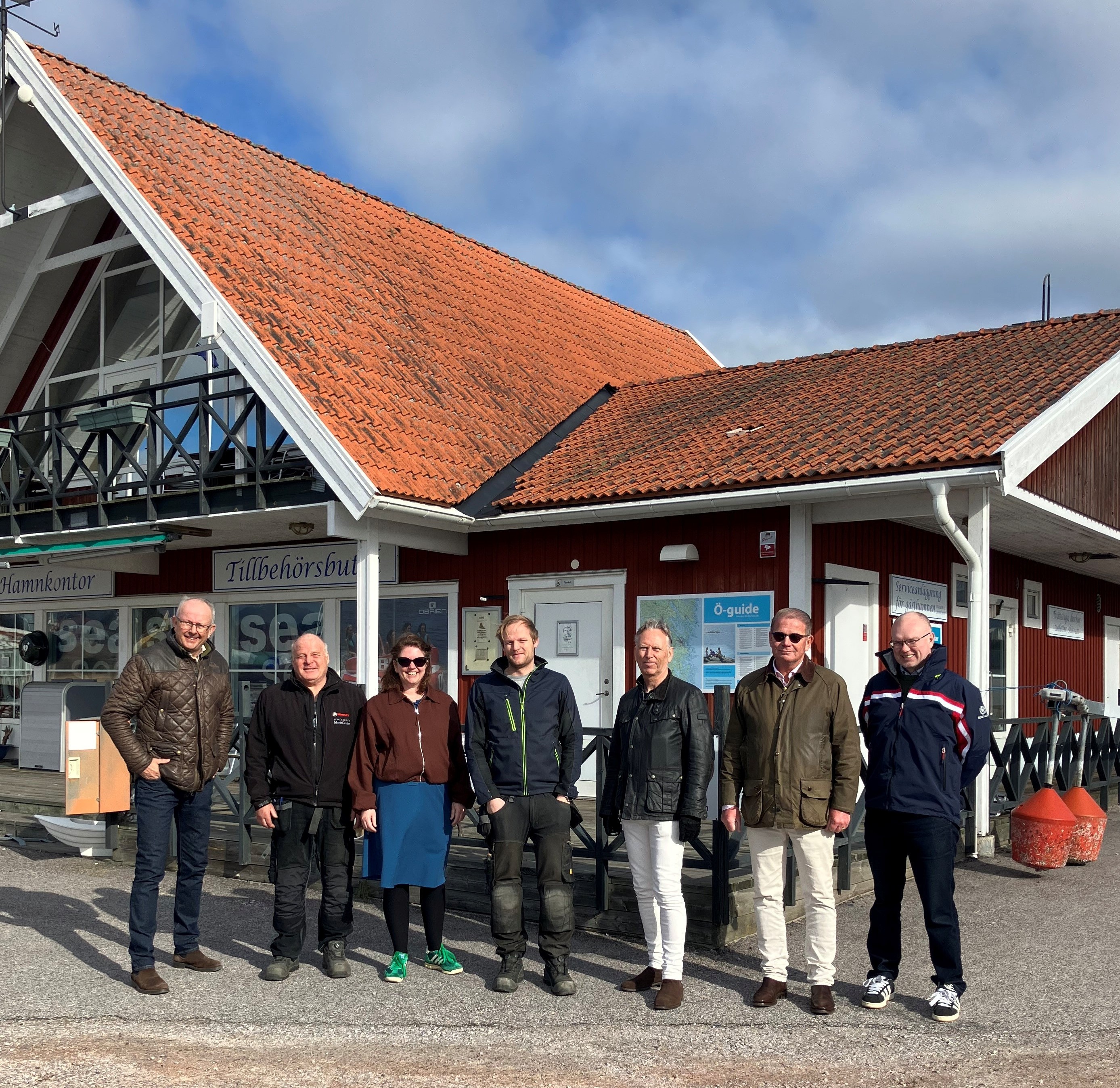 En grupp personer på bild framför ett hus