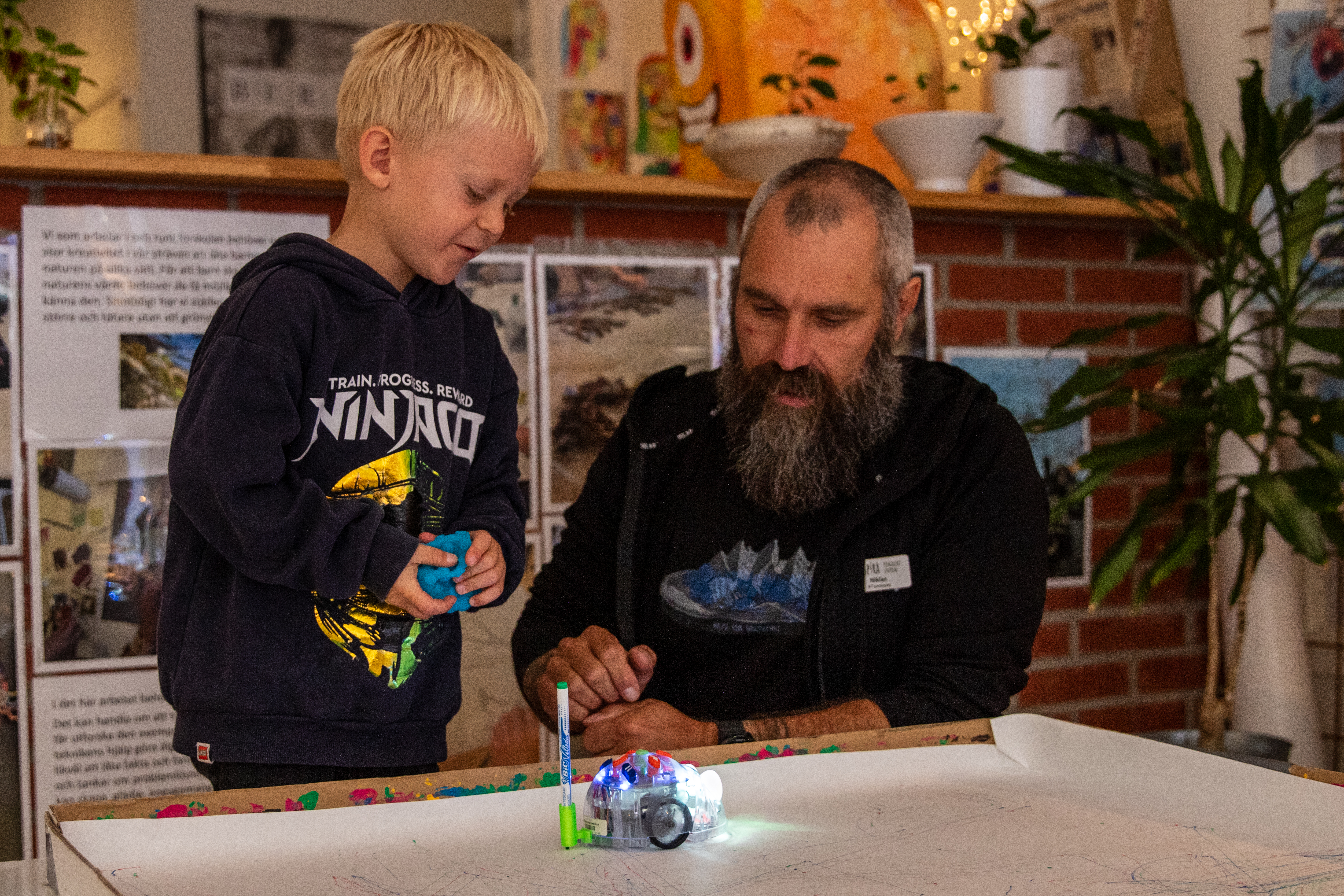 IKT-pedagog och barn leker med robot.