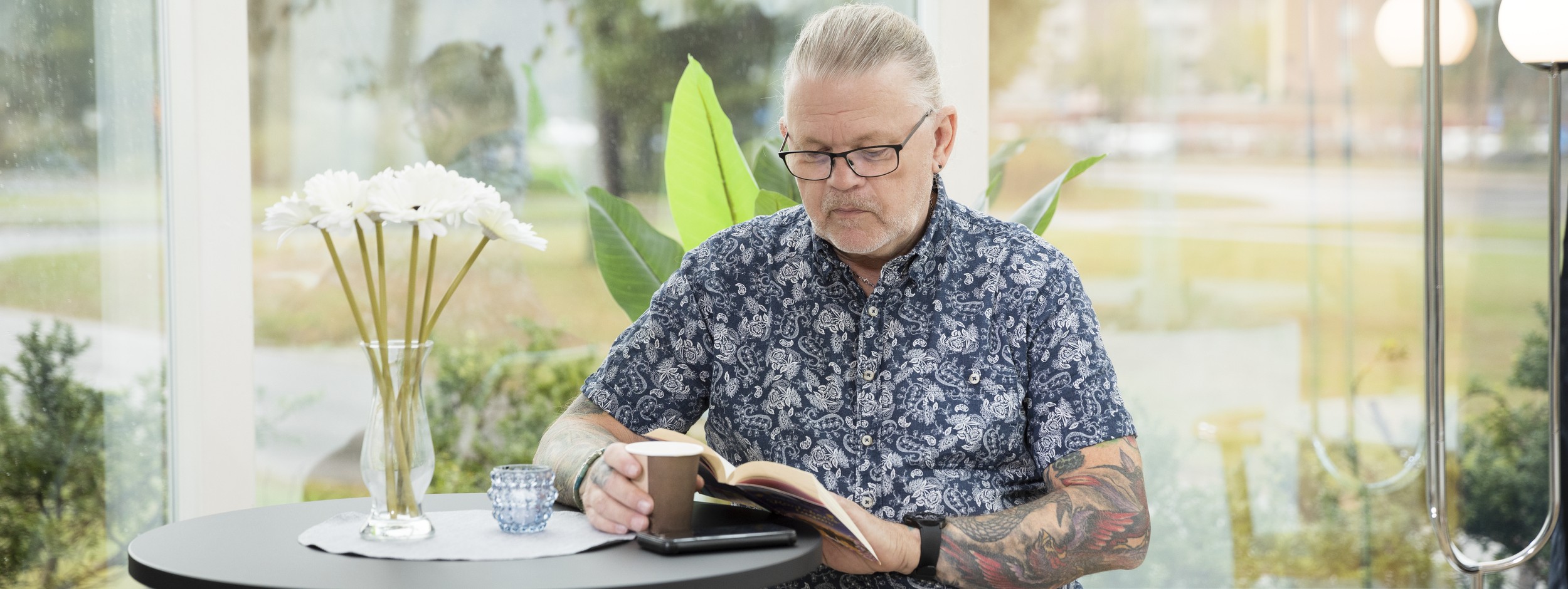 Bild på en glad kvinna som har rött hår och färgglada kläder.