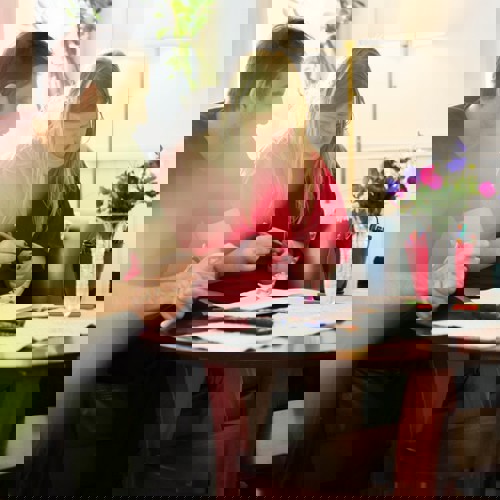 Kille som sitter runt soffbord med kvinna.