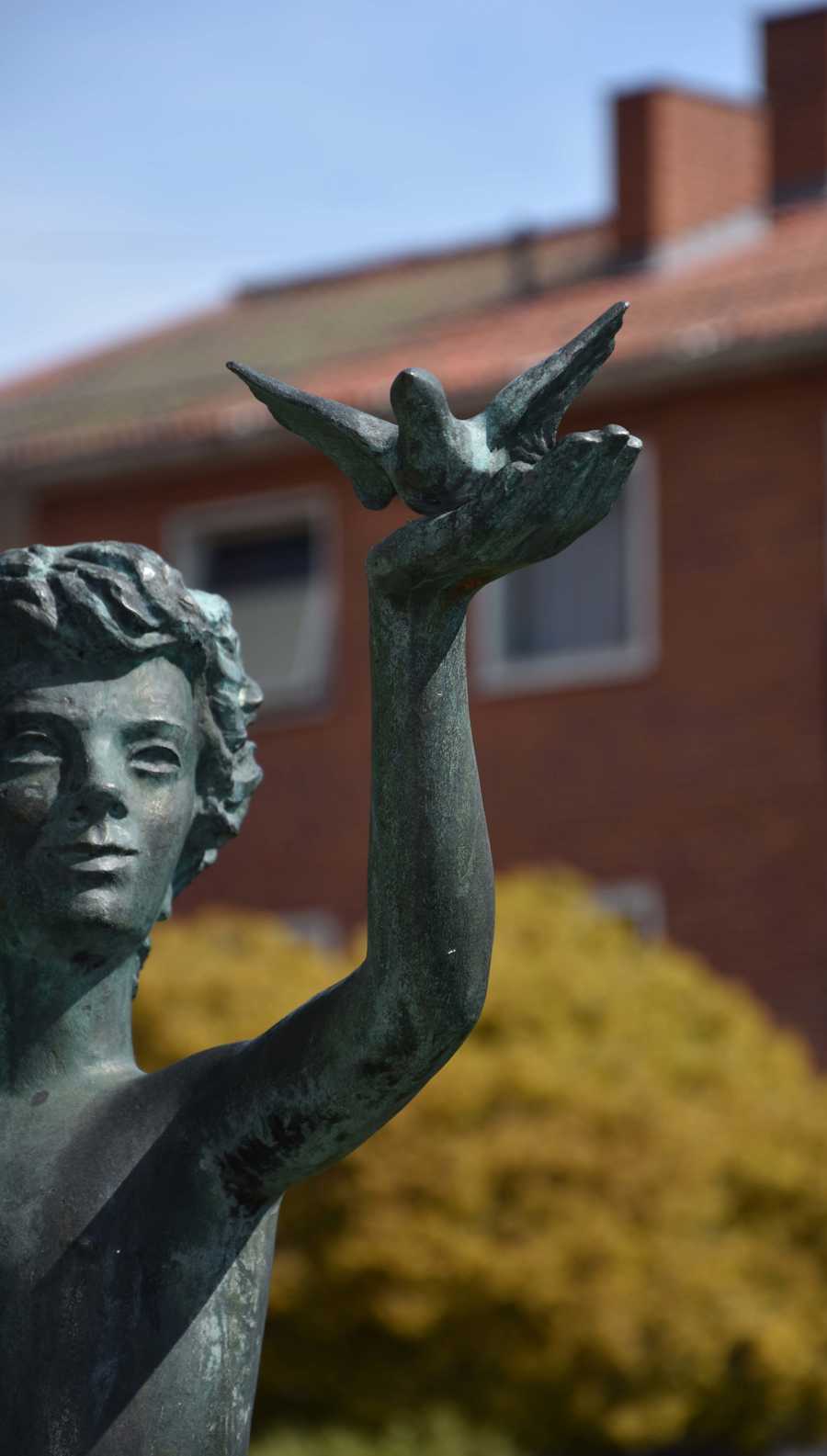 Staty föreställande pojke med en fågel i sin utsträckta hand.