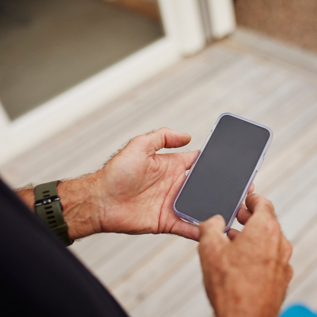 Händer som håller i telefon.