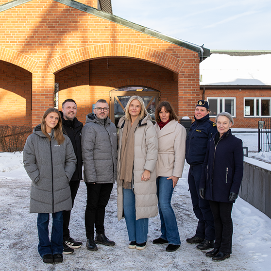 Gruppbild på representanter från skola, socialtjänst, fritid, polis och familjeenheten utanför kommunhuset.