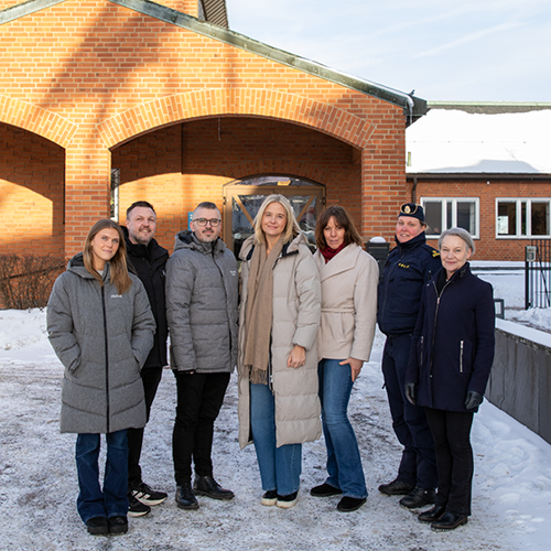 Gruppbild på representanter från skola, socialtjänst, fritid, polis och familjeenheten utanför kommunhuset.