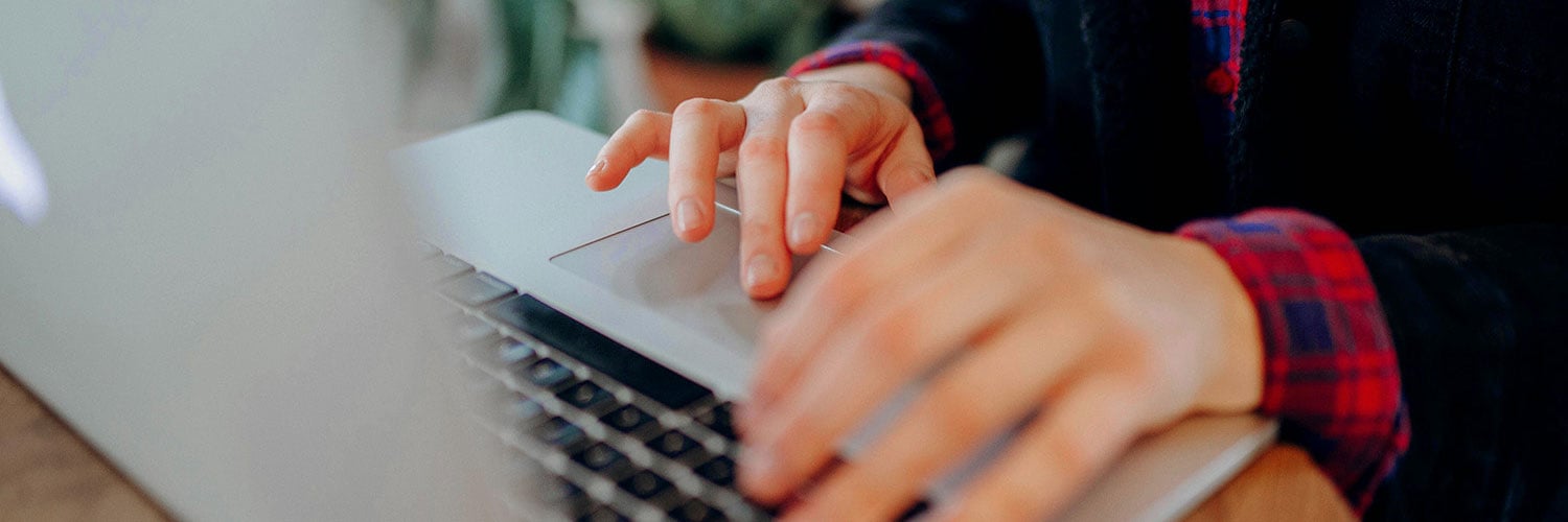 Händer på en laptops tagentbord.