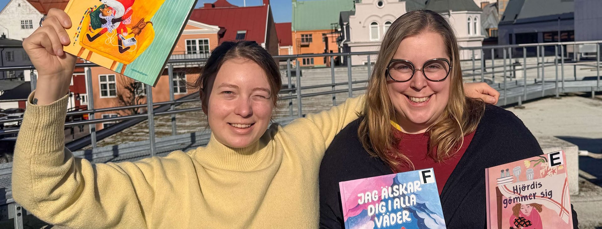 Bibliotekarier som håller i barnböcker. 