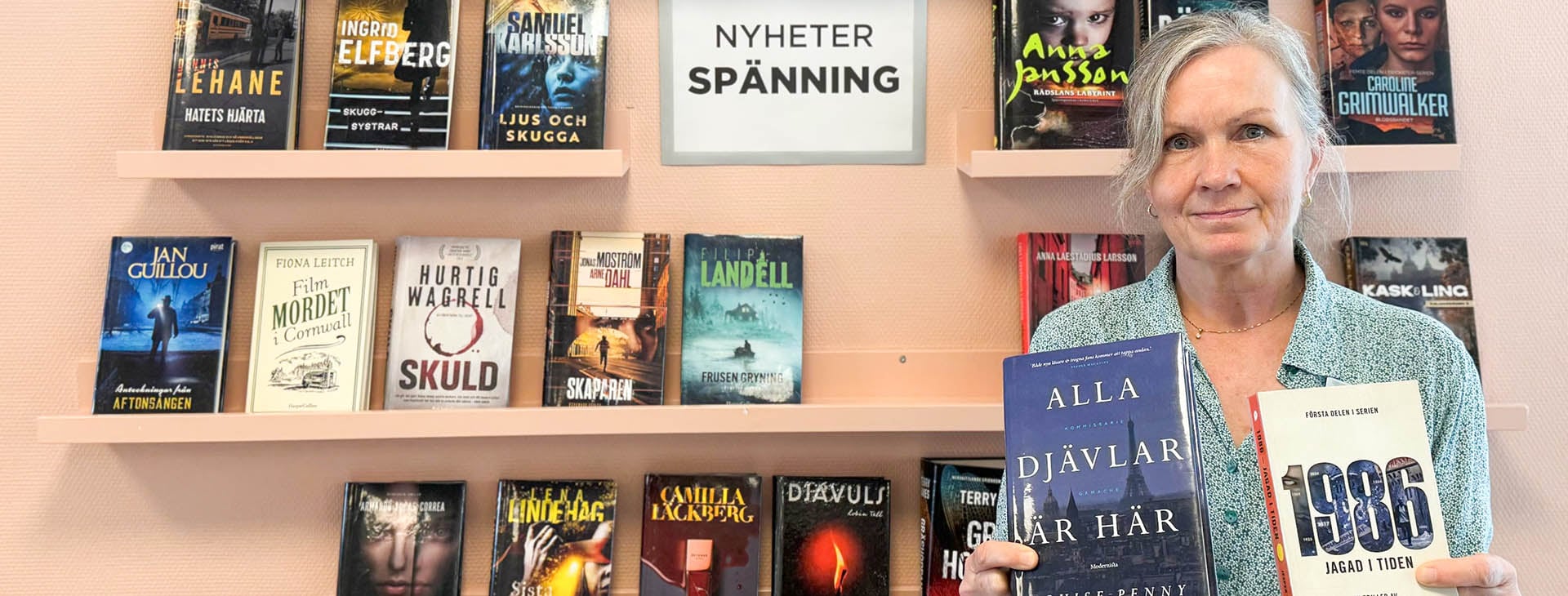 Bibliotekarie framför bokhylla. 