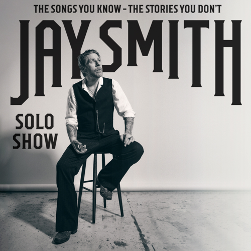 Jay Smith sitter på en vit stol