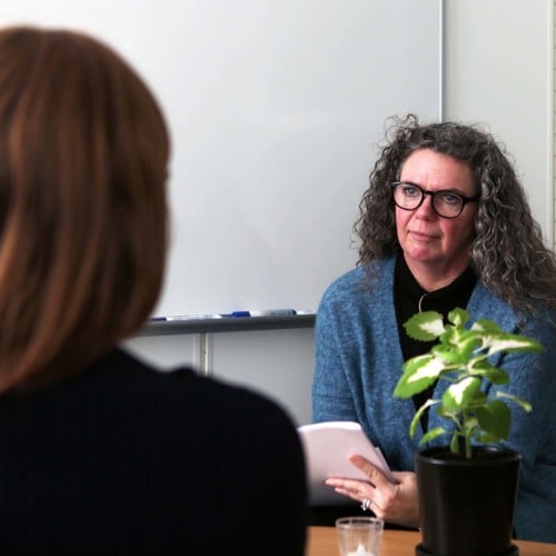 Yrkeskvinna i samtal med ungdom.