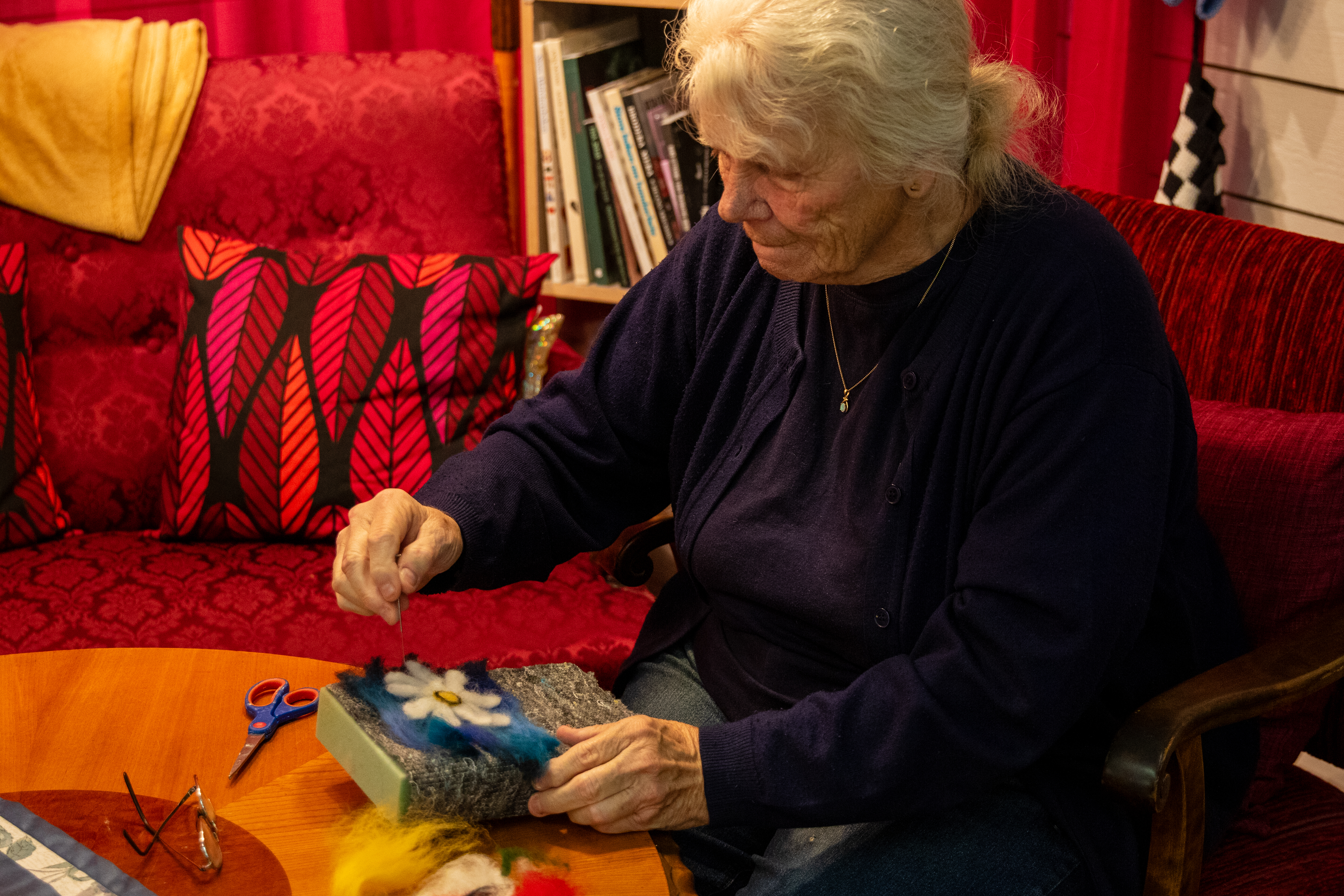 Ulla sitter i fotölj och tovar.