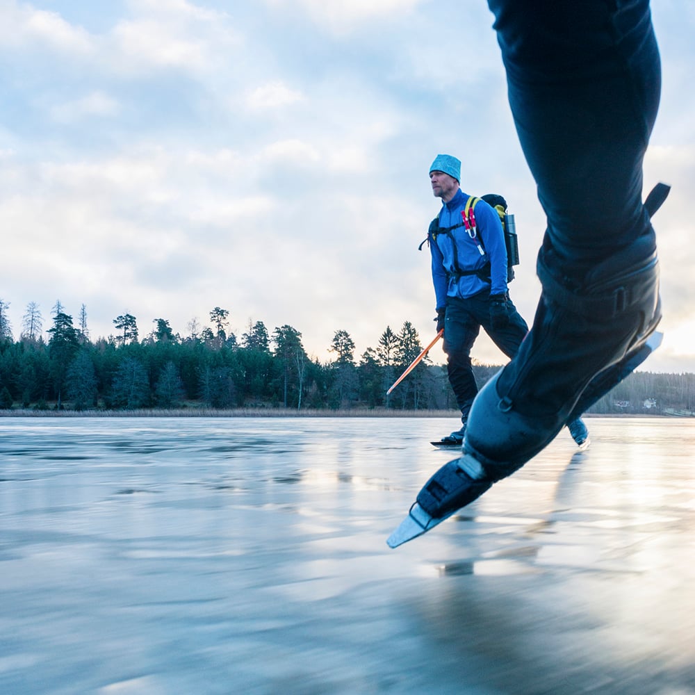bild på två personer som åker långfärdsskridskor på blank is