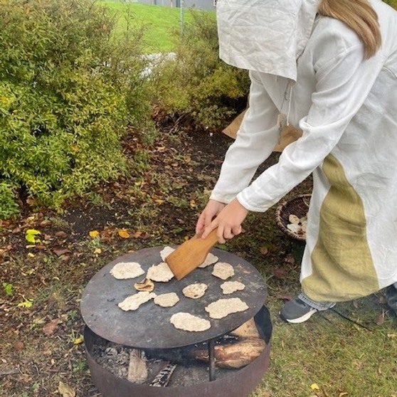 Elev som steker bröd på en häll under medeltiden.