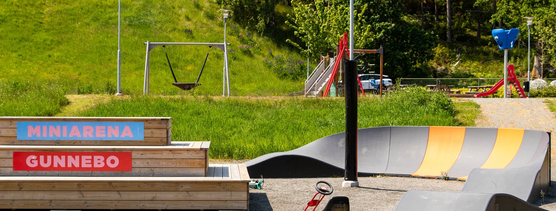 Lekplatsen i Gunnebo med skyltar med texten Miniarena Gunnebo och lekredskap.