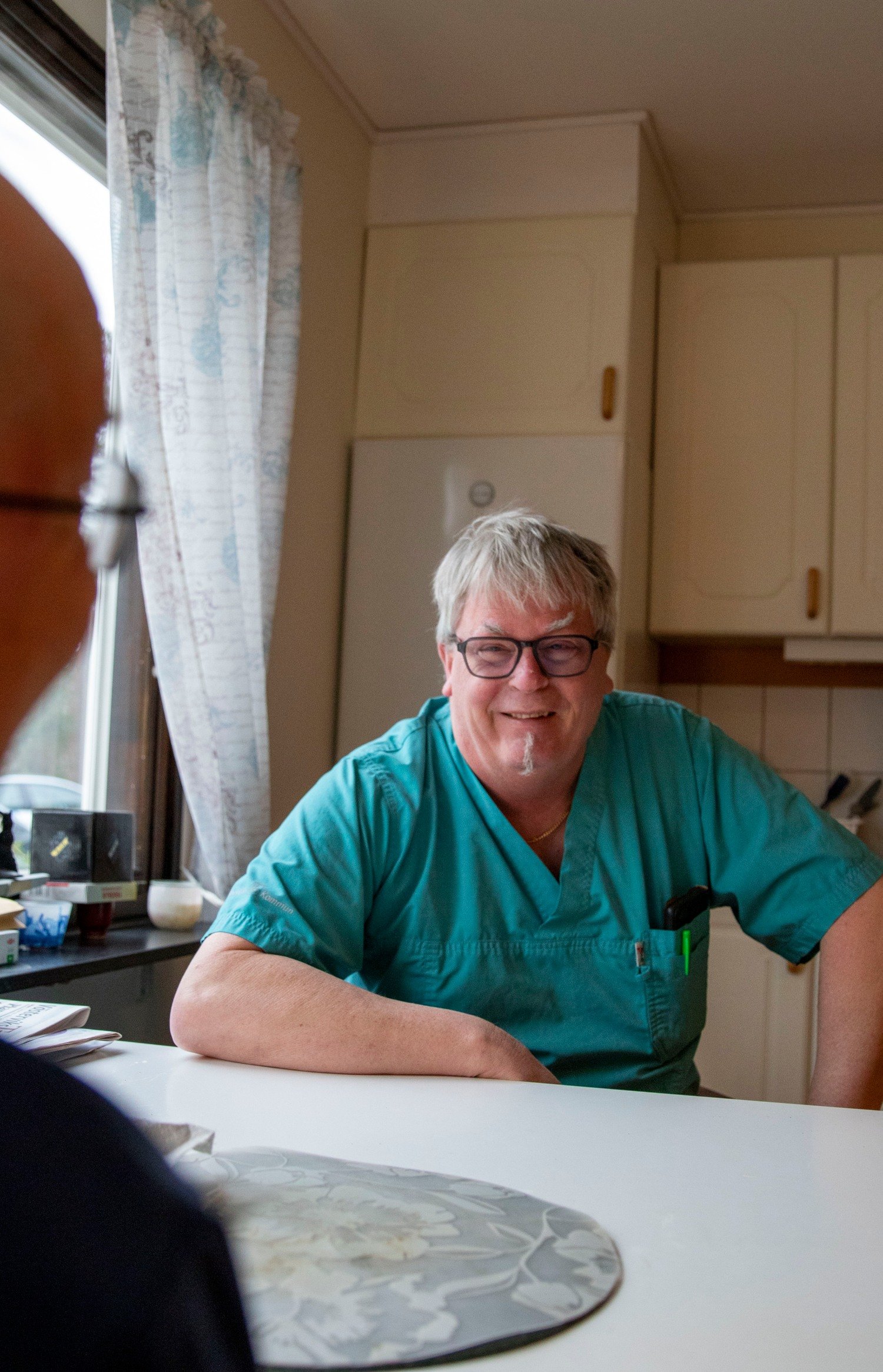 Lasse pratar med en omsorgstagare och skrattar.