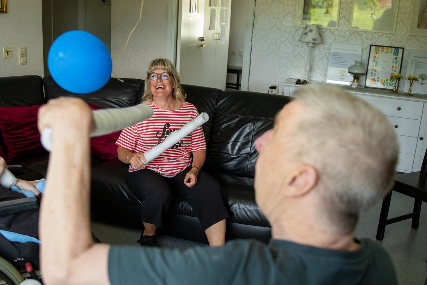 Ylva spelar ballongspel med en brukare.