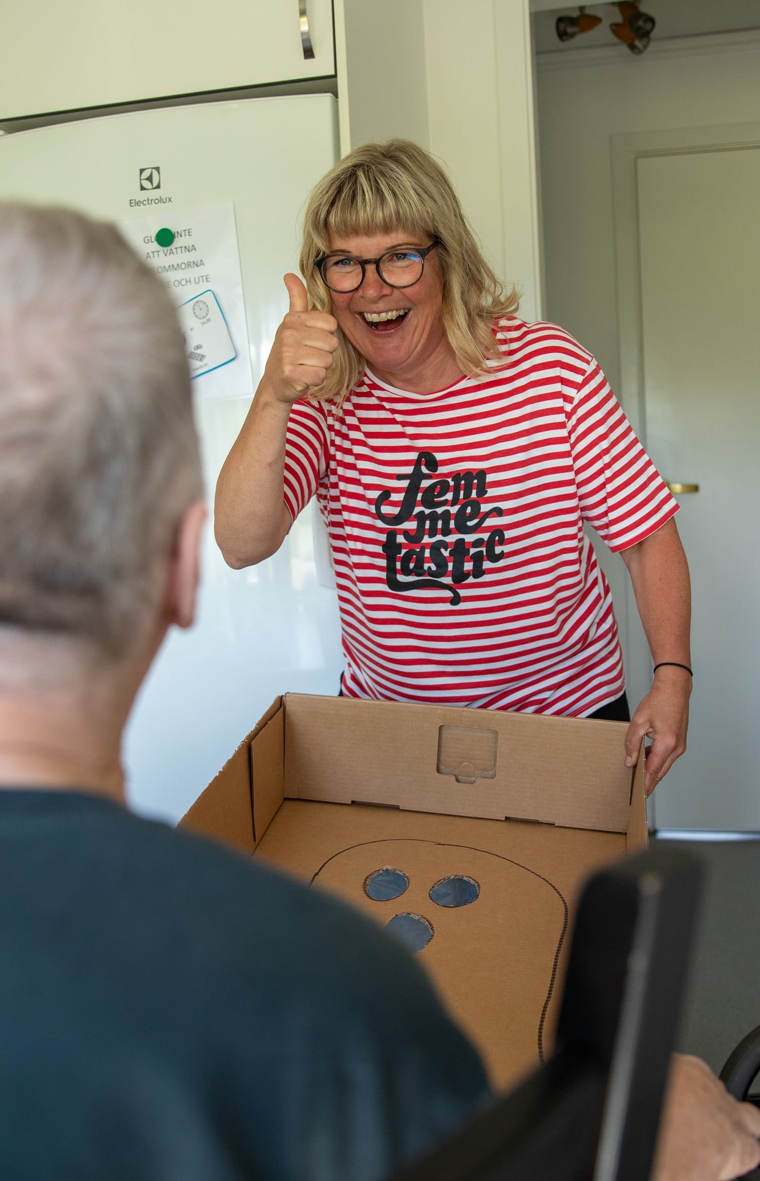 Ylva spelar spel med brukare och gör tummen upp.