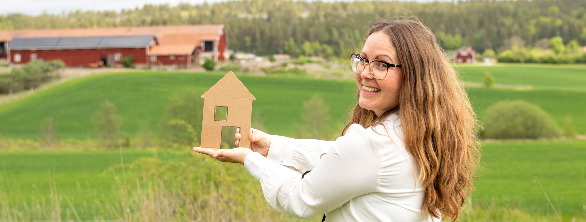 Modell på ett hus över ett fält.