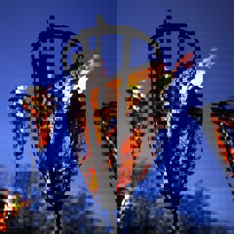 Brinnande eldkorg i skymning.