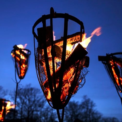 Brinnande eldkorg i skymning.