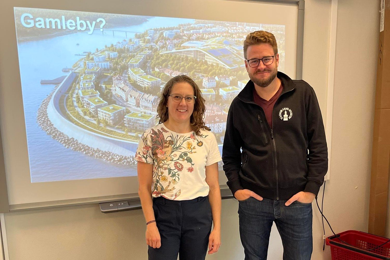 Bild på hur Gamleby kan se ut i framtiden visas på en projektor med personal från Kalmar läns museum framför.