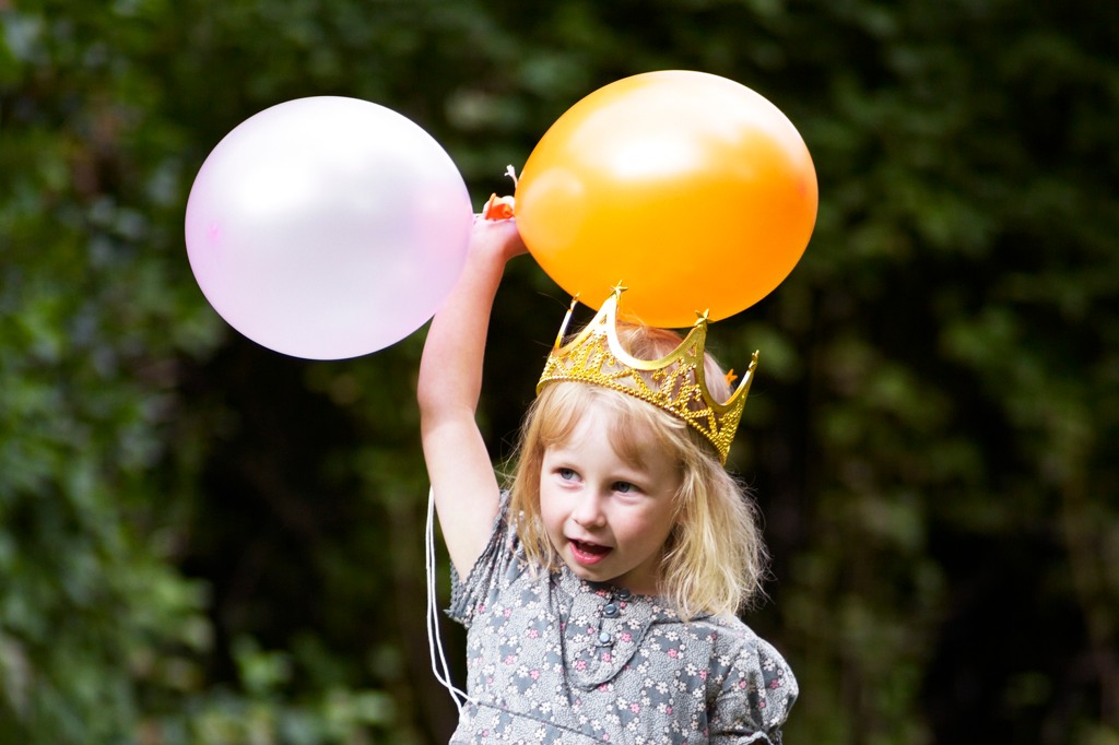 en flicka med två ballonger