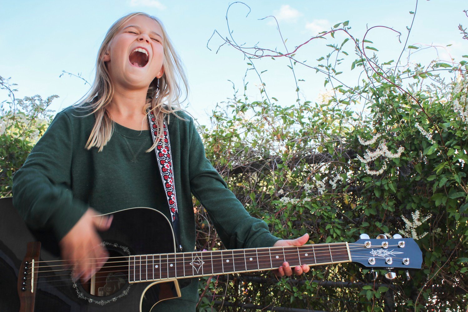Flicka spelar gitarr och sjunger.