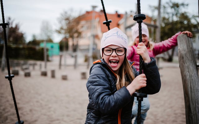 Glada flickor leker i lekpark