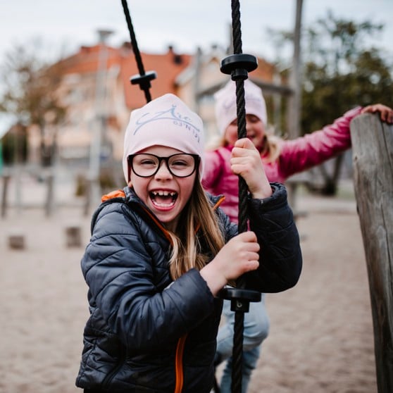 Glada flickor leker i lekpark