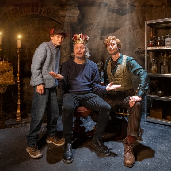 Regissören Calle Åstrand bredvid skådespelarna iklädd en kungakrona.