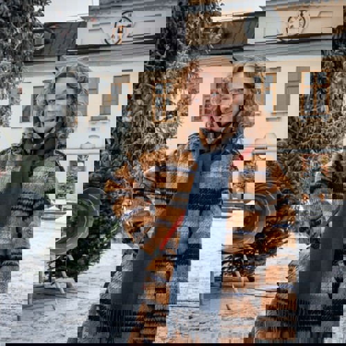 Skådespelaren mamma Moa syns bredvid en snöig julgran på Stora torget.