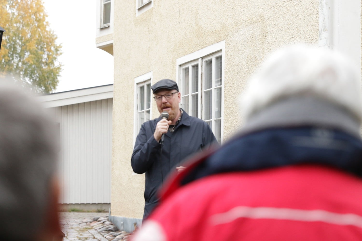 En man som står framför en folkmassa och håller i en mikrofon.