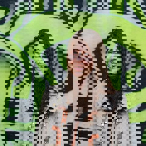 Ung kvinna framför en väggmålning.