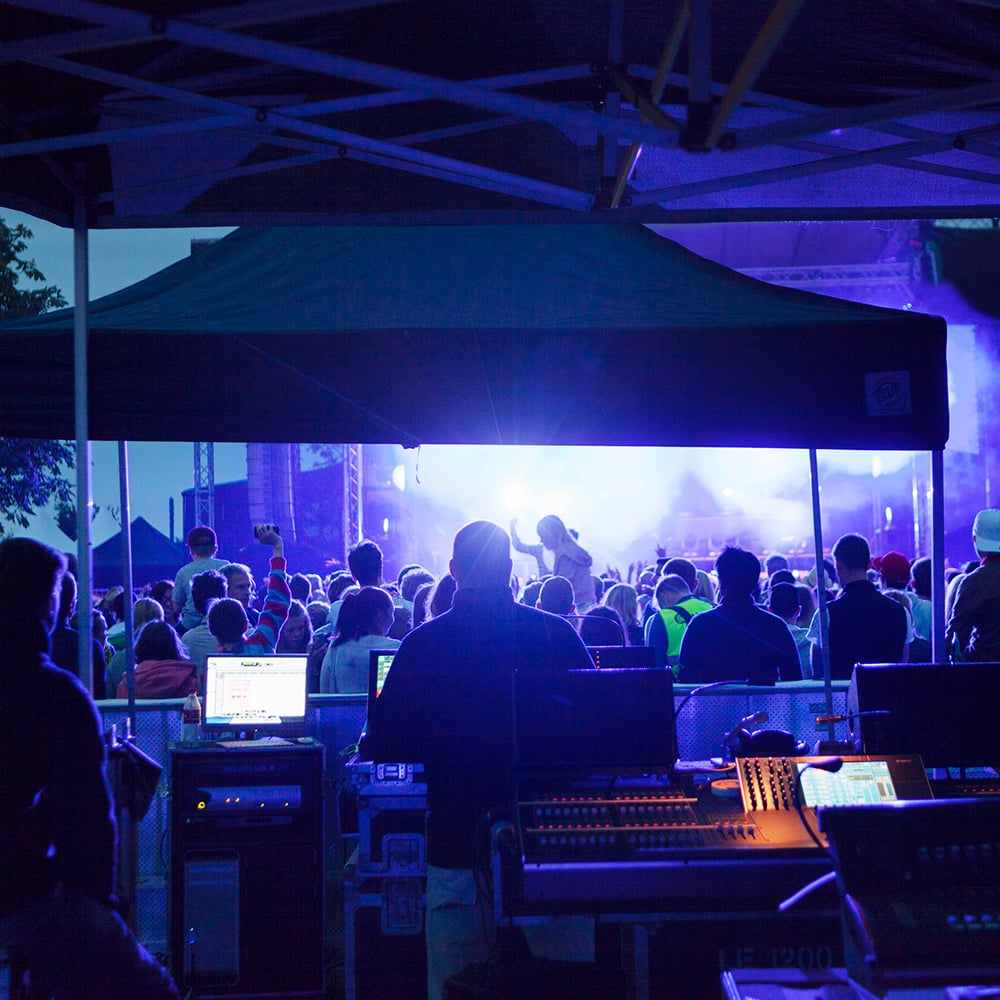bild på en mixplats framför publik och en scen på ett musikevenemang