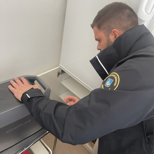 Kommunens beredskapshandläggare Enis Skeja med en powerbank hos skolsyster