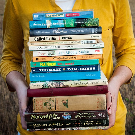 bild på person med trave med böcker