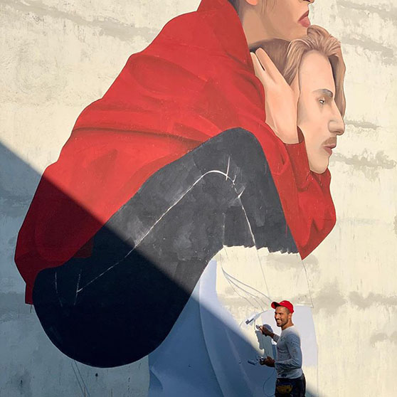 Konstnären Artez målar en vägg