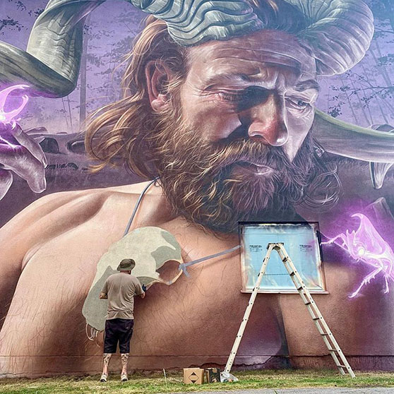 Konstnären Smug målar en vägg i Edsbruk