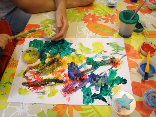 Händer på vuxen och barn som målar teckning