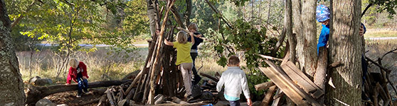 Barn som bygger koja bland träd
